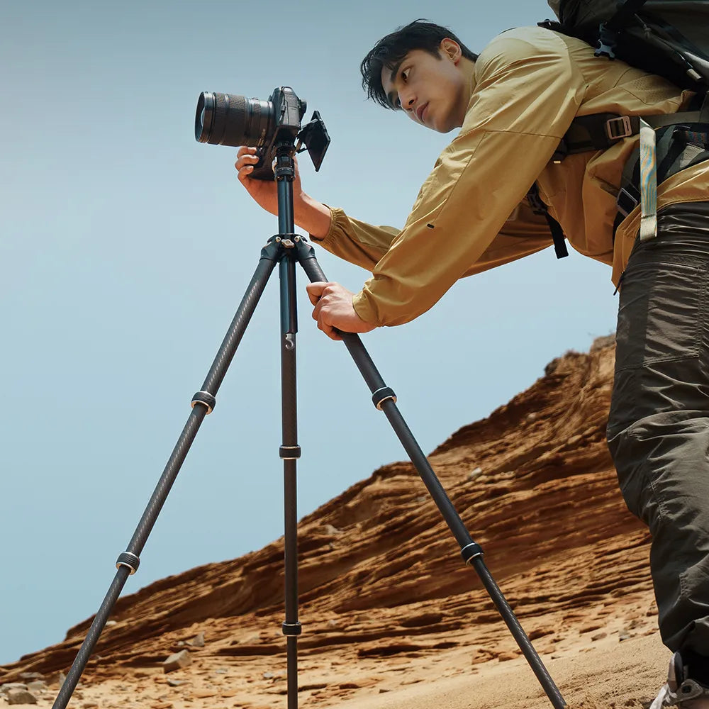 Fotograf mit TreeRoot Quick Lock Lite-Stativ in einer Wüstenlandschaft.