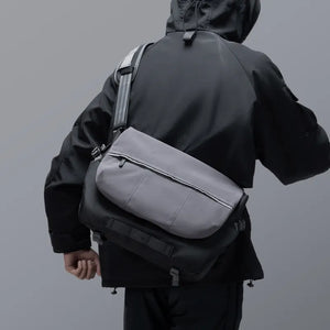 Person, die eine Kamera-Schultertasche trägt, von hinten gesehen.